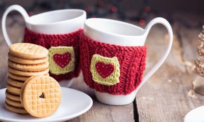 Two cute cups of coffee with hearts in red fabric on them.