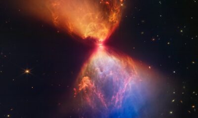 a galaxy that looks like an hourglass pinched at the center with a shining protostar