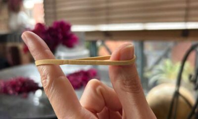 A rubber band stretched between finger and thumb