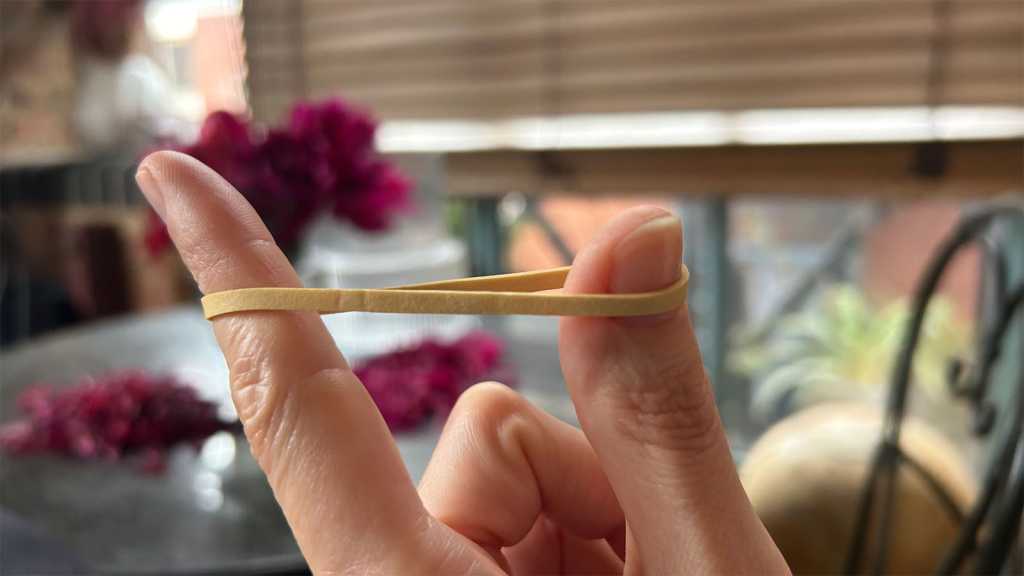 A rubber band stretched between finger and thumb