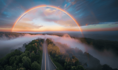 A rainbow over a highway early in the morning.