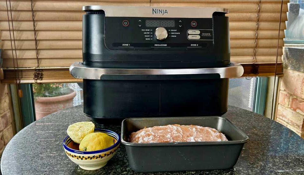 Ninja air fryer with a loaf cake in a tine in front of it