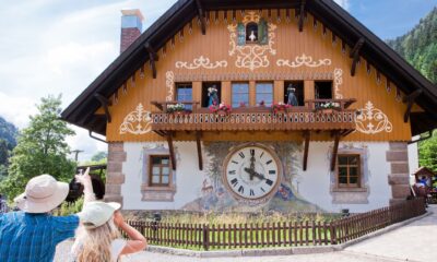 two people standing and looking at a cuckoo clock on a hotel
